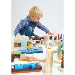 Enfant à genou qui joue avec le circuit de train géant en bois - Vue sur la montagne - Tender Leaf